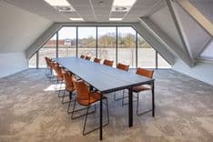 Vergaderruimte Harry Frens met lange tafel, 12 stoelen en veel daglicht door grote ramen — Mudde Kok FlexCentre