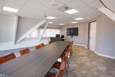 Vergaderruimte Harry Frens met lange tafel, 12 stoelen en 75-inch scherm — Mudde Kok FlexCentre