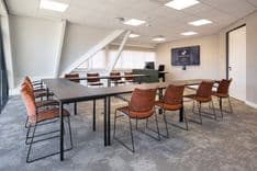 Harry Frens kamer in cursusopstelling voor 12 personen met 75-inch scherm en ramen met uitzicht — Mudde Kok FlexCentre