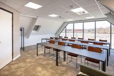 Harry Frens kamer in cursusopstelling voor 16 personen met tafels, stoelen, 75-inch scherm en ramen met daglicht — Mudde Kok FlexCentre