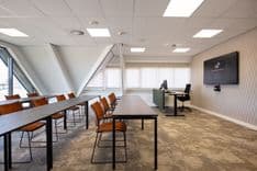 Harry Frens kamer in cursusopstelling voor 16 personen met tafels, stoelen, 75-inch scherm en ramen met daglicht — Mudde Kok FlexCentre