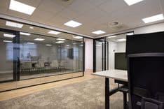 Overzicht van kantoorruimte Jan van Vuuren met 2 ergonomische werkplekken en glazen wand