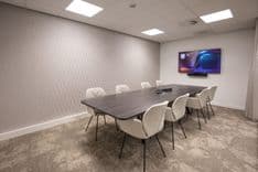Overzicht van vergaderruimte Arthur Briët met 8 stoelen en 65-inch scherm