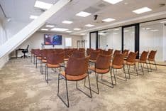 Huib van de Vecht zaal in lezingopstelling voor 50 personen met 86-inch scherm — Mudde Kok FlexCentre