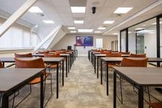 Huib van de Vecht zaal in cursusopstelling voor 12 personen met 86-inch scherm — Mudde Kok FlexCentre