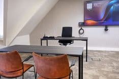 Huib van de Vecht zaal in cursusopstelling voor 12 personen met scherm en stoelen — Mudde Kok FlexCentre