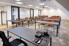 Huib van de Vecht zaal in cursusopstelling voor 30 personen met vaste werkplekken en scherm — Mudde Kok FlexCentre