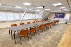 Huib van de Vecht zaal in vergaderopstelling voor 12 personen met 86-inch scherm — Mudde Kok FlexCentre