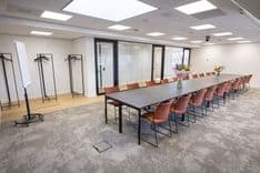 Huib van de Vecht zaal in vergaderopstelling voor 12 personen met 86-inch scherm — Mudde Kok FlexCentre
