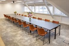 Huib van de Vecht zaal in vergaderopstelling voor 16 personen met 86-inch scherm — Mudde Kok FlexCentre