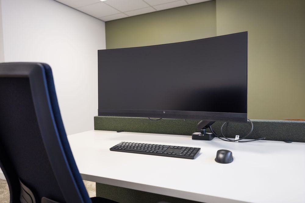 Tante Cor kamer met zit-sta bureau, 34-inch curved monitor, toetsenbord en muis — Mudde Kok FlexCentre
