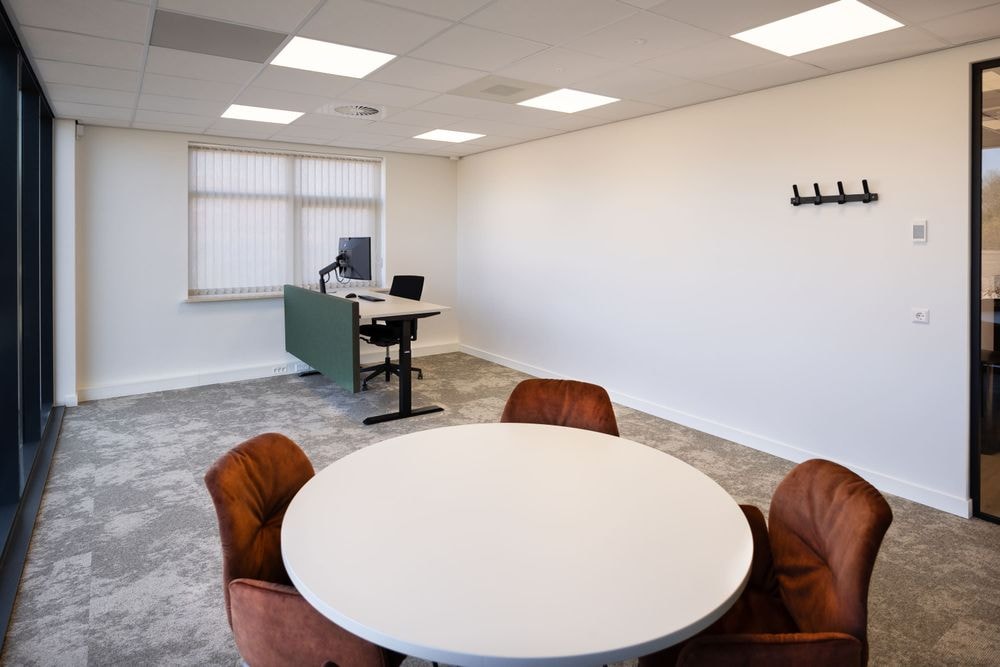 Vergadertafel en werkplek met bureau in de Pieter IJzerman-kamer