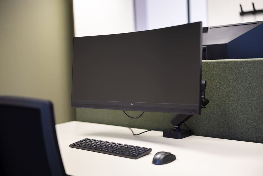 Detail van ergonomische werkplek met 34-inch curved monitor in Gerrit Mazier kantoor