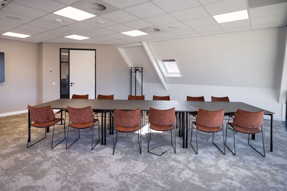 Vergaderruimte Harry Frens met 12 stoelen en lange tafel, zicht op deurzijde — Mudde Kok FlexCentre