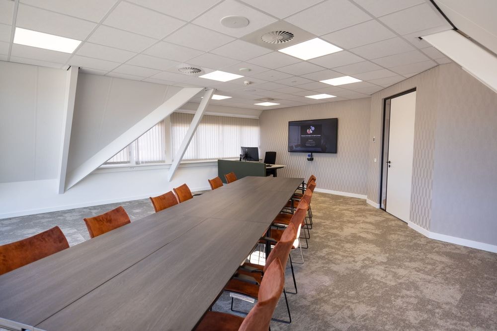 Vergaderruimte Harry Frens met lange tafel, 12 stoelen en 75-inch scherm — Mudde Kok FlexCentre