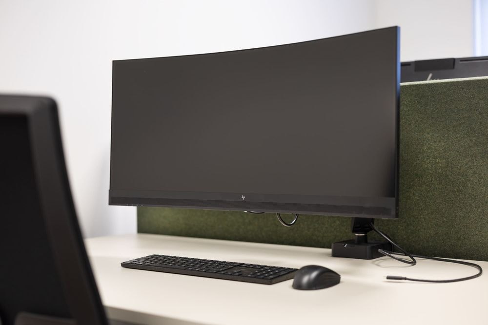 Detail van ergonomische werkplek met 34-inch curved monitor in Jos Lussenburg kantoor