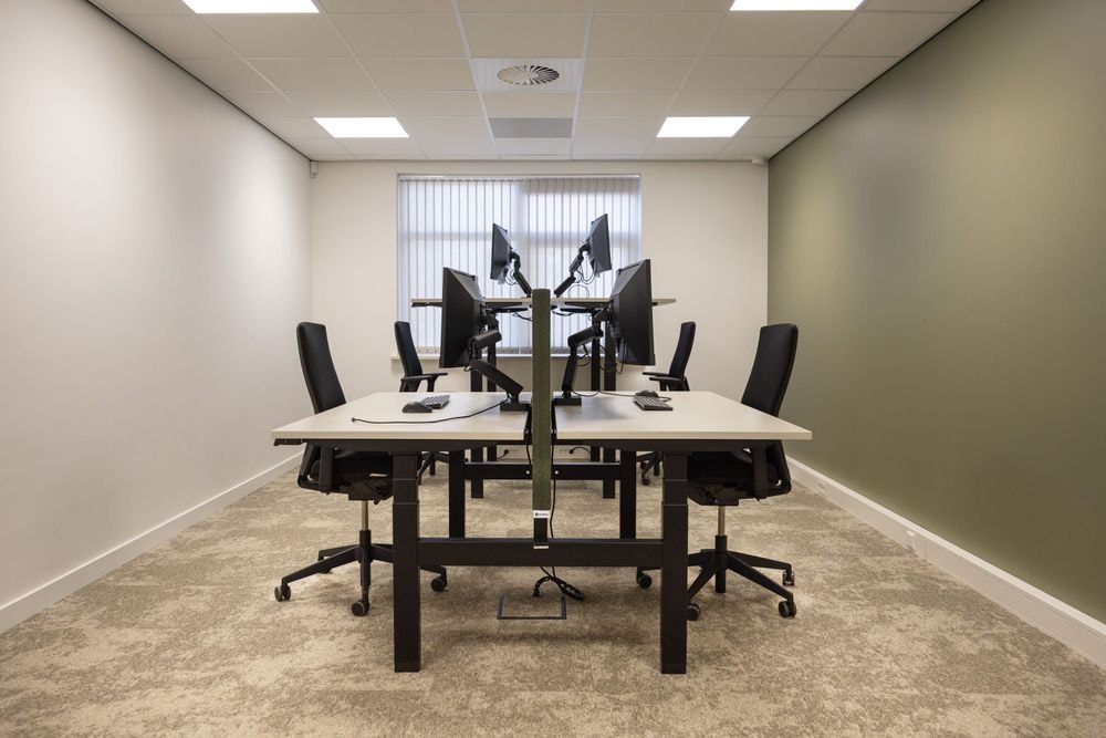 Kantoorruimte Chris ten Bruggen Kate met groene wand en 3 ergonomische werkplekken