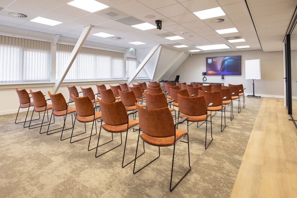 Huib van de Vecht zaal in lezingopstelling voor 50 personen met 86-inch scherm — Mudde Kok FlexCentre