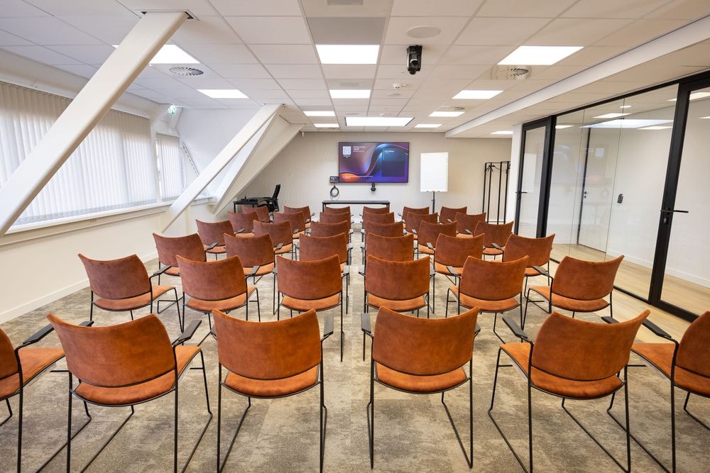 Huib van de Vecht zaal in lezingopstelling voor 50 personen met 86-inch scherm — Mudde Kok FlexCentre
