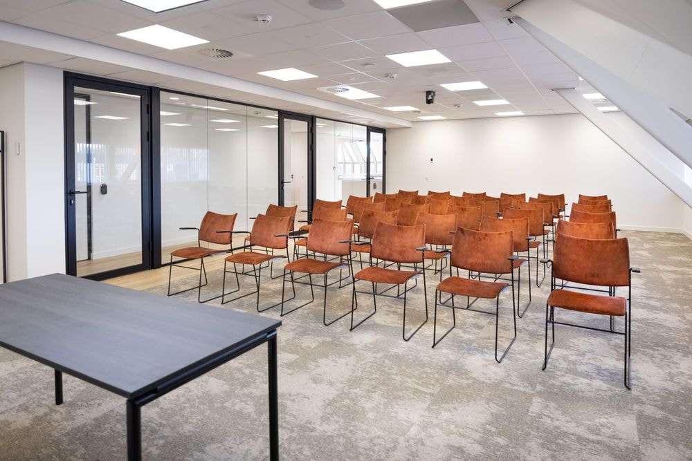 Huib van de Vecht zaal in lezingopstelling voor 50 personen met 86-inch scherm — Mudde Kok FlexCentre