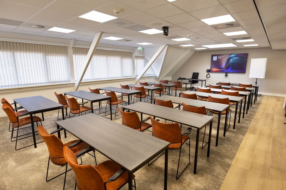 Huib van de Vecht zaal in cursusopstelling voor 12 personen met 86-inch scherm — Mudde Kok FlexCentre