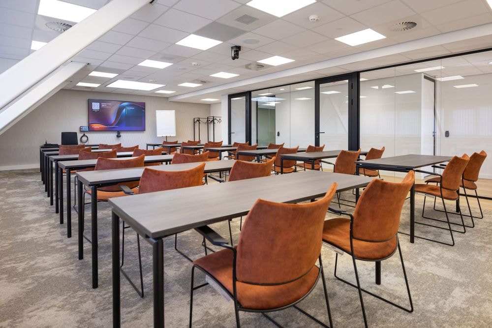 Huib van de Vecht zaal in cursusopstelling voor 12 personen met 86-inch scherm — Mudde Kok FlexCentre