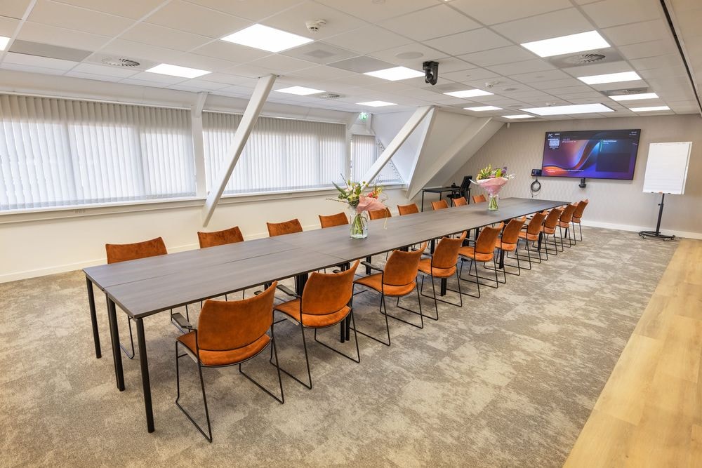 Huib van de Vecht zaal in vergaderopstelling voor 20 personen met 86-inch scherm — Mudde Kok FlexCentre