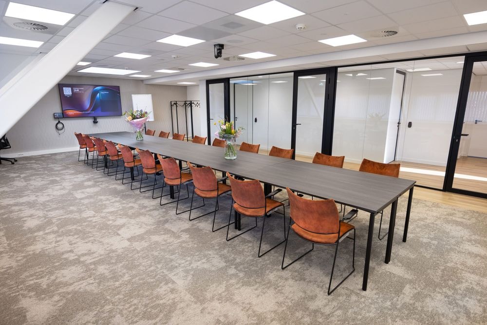 Huib van de Vecht zaal in vergaderopstelling voor 16 personen met 86-inch scherm — Mudde Kok FlexCentre