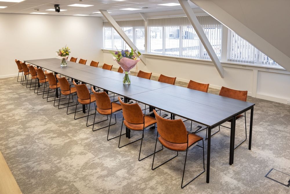 Huib van de Vecht zaal in vergaderopstelling voor 16 personen met 86-inch scherm — Mudde Kok FlexCentre