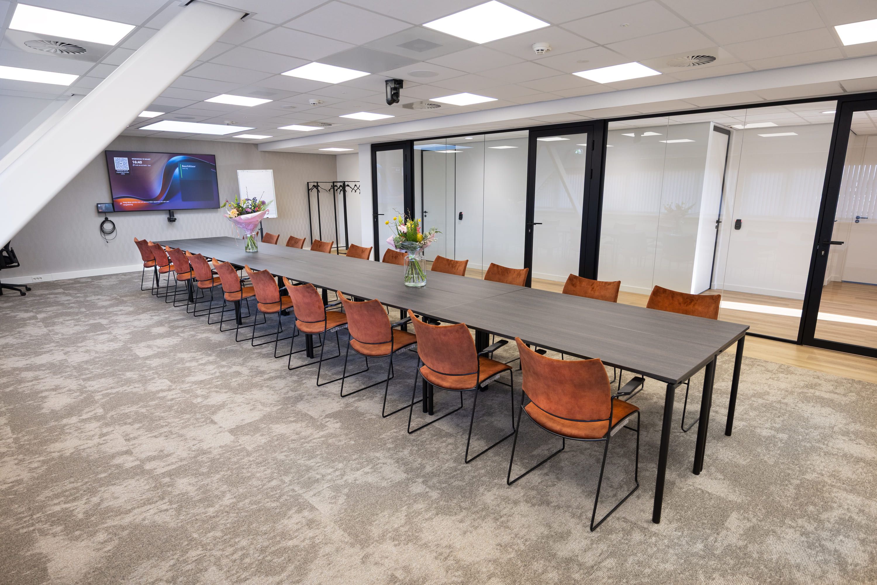 Huib van de Vecht zaal in vergaderopstelling voor 20 personen met 86-inch scherm — Mudde Kok FlexCentre